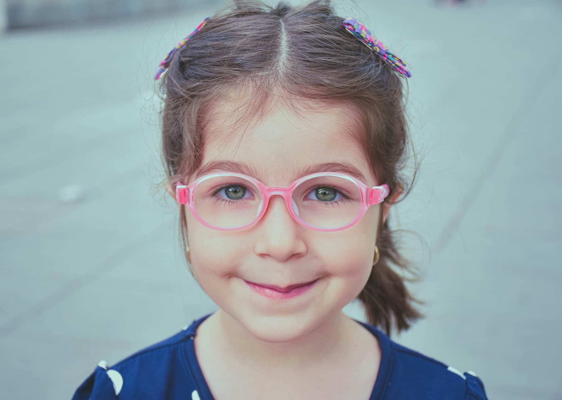 A child smiling in her new prescription glasses